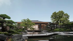 A modern residential garden featuring concrete and glass materials with a serene water feature.
