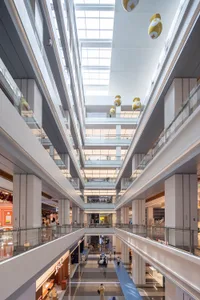 Modern shopping mall interior with glass, concrete and lighting features
