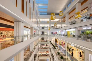 View of a modern shopping center with multiple levels and various retail stores.