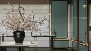 A minimalist living room featuring glass walls and sleek modern furnishings.