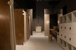 Minimalist locker room featuring stone, wood, and concrete materials.