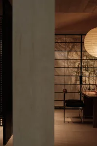 Minimalist modern interior with concrete walls and floor, featuring geometric shapes and natural light.