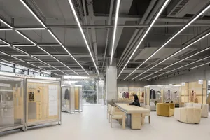 An image of a modern office with concrete and glass interiors, featuring a minimalist design.