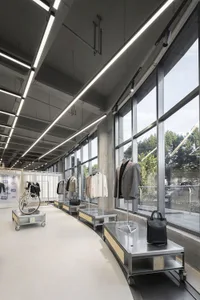 Retail shop interior with metal counters and clothing displays.