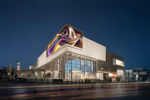 Modern retail building with glass and metal exterior at night.