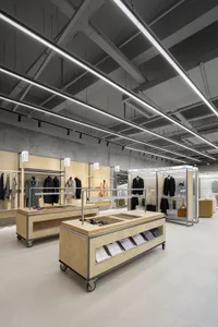 一間服裝零售店，擁有木質表面、金屬欄杆與混凝土牆面。