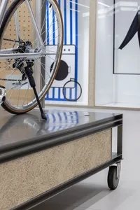 Industrial-style urban service cart with metal body and plywood lining, featuring a bicycle kickstand.