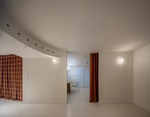 A minimalist, modern apartment interior with a white interior design, featuring a smooth plaster finish on the walls and floo