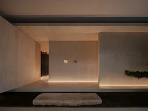 A modern interior space with a minimalist design featuring concrete walls and floor.