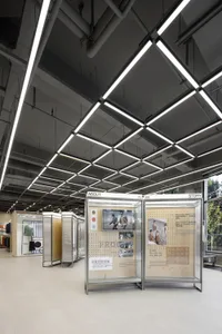 Modern retail space featuring glass and metal structural elements and lighting.