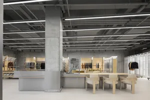 Modern retail store interior with minimalist design, open-plan layout, and exposed concrete and steel construction elements.