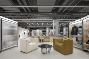 A modern showroom with metal, glass, and fabric materials.