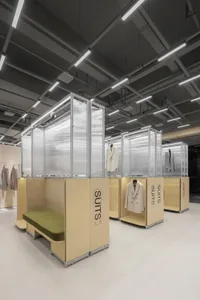 Modern clothing display featuring suits in wood enclosures with glass fronts.