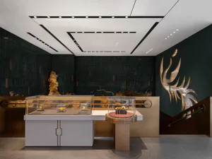 A minimalist retail storefront featuring a metal showcase with various objects displayed inside.