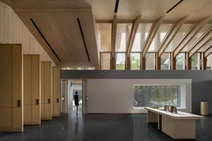 A modern hotel lobby with wooden walls and ceiling, a black marble floor, and large windows.