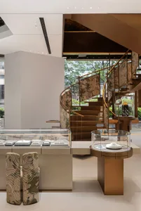 Modern jewelry shop interior with a wooden spiral staircase.