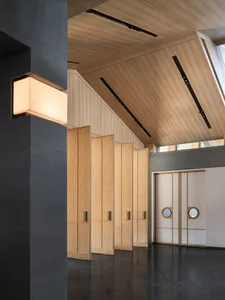 Modern industrial design lobby interior with wooden paneling and lighting.