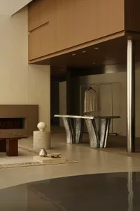 Minimalist interior with metallic table and travertine elements