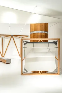 A minimalist storefront with a white space and wooden structures.
