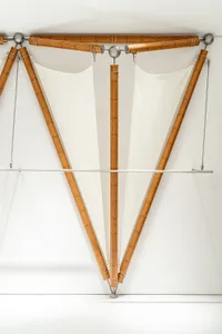 A modern art installation featuring wooden elements hanging from the ceiling.