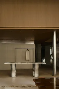 A modern clothing store display featuring a metal table with marble legs, and a hanging garment.