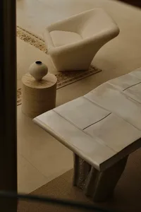 A modern living room featuring concrete furniture and decor elements.