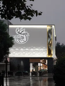 Modern storefront with a metallic façade featuring illuminated signage and a cloud-like pattern.