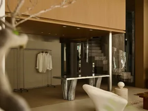 A modern interior space featuring a metallic table with a unique, sculptural design.