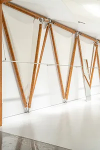 A minimalist interior design featuring wood frames and white textiles.