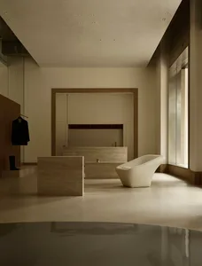 A minimalist modern living room with a concrete floor, wall, and furniture.