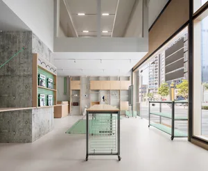 A modern, minimalist pet store with concrete and wood finishes, featuring green accents and open shelving units.