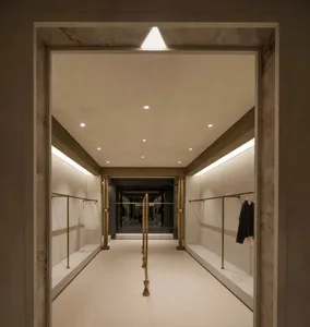 An image of a modern clothing store with concrete walls, metal railings, and glass storefront.