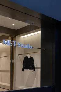 現代零售店面，玻璃櫥窗展示一件黑色皮夾克。
