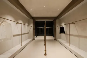 A sleek, modern storefront with a concrete exterior and metal accents, featuring a glass window and a clean, minimalist desig