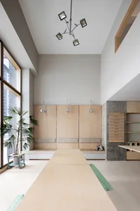 A modern workspace featuring wooden panels, concrete walls, and glass windows.