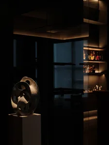 Modern bar interior with glass shelving and illuminated bottles.