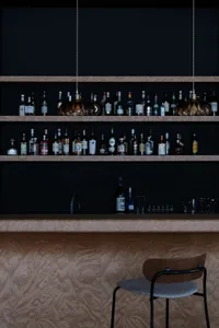 A sleek and modern bar area featuring a wooden texture and concrete finishes.