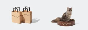 A cat sitting in a cardboard cat bed.