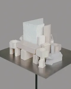 A minimalist architectural model made of white paper materials