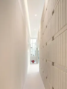 A minimalist corridor with concrete walls and floor.