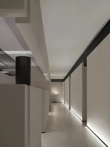 Modern interior design featuring a sleek, minimalist corridor with concrete walls and floor, illuminated by soft, ambient lig