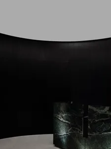 A sleek, modern marble counter with a dark wooden backdrop.