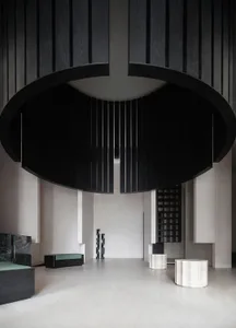 Modern minimalist lobby interior with black wood, marble, and concrete tiles.