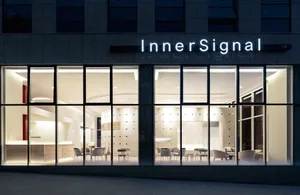 Modern retail storefront with illuminated glass facade at night.
