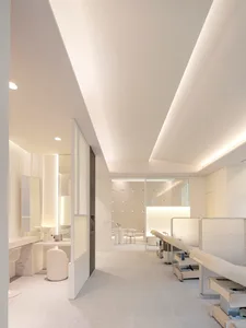 A modern spa interior featuring a clean, minimalist space with white walls and furniture.