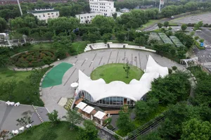 A park with a sculpture, concrete tents, and greenery