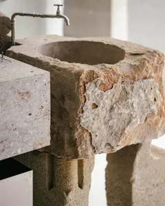 An industrial-style bathroom with a stone sink and faucet.