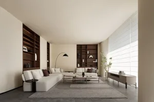 A minimalist living room with a white sectional sofa, a round wooden coffee table, and dark wood bookshelves.