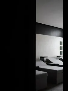 A minimalist living room featuring textured wall paper and sleek, modern furniture.