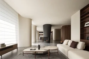 Contemporary living room featuring a minimalist design with concrete and wood finishes, including a fireplace and a cozy sofa